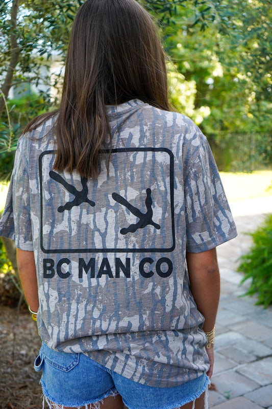 Woman wearing the BC Man Co Turkey Track Vintage Camo Tee, an oversized unisex camo t-shirt with turkey track back logo
