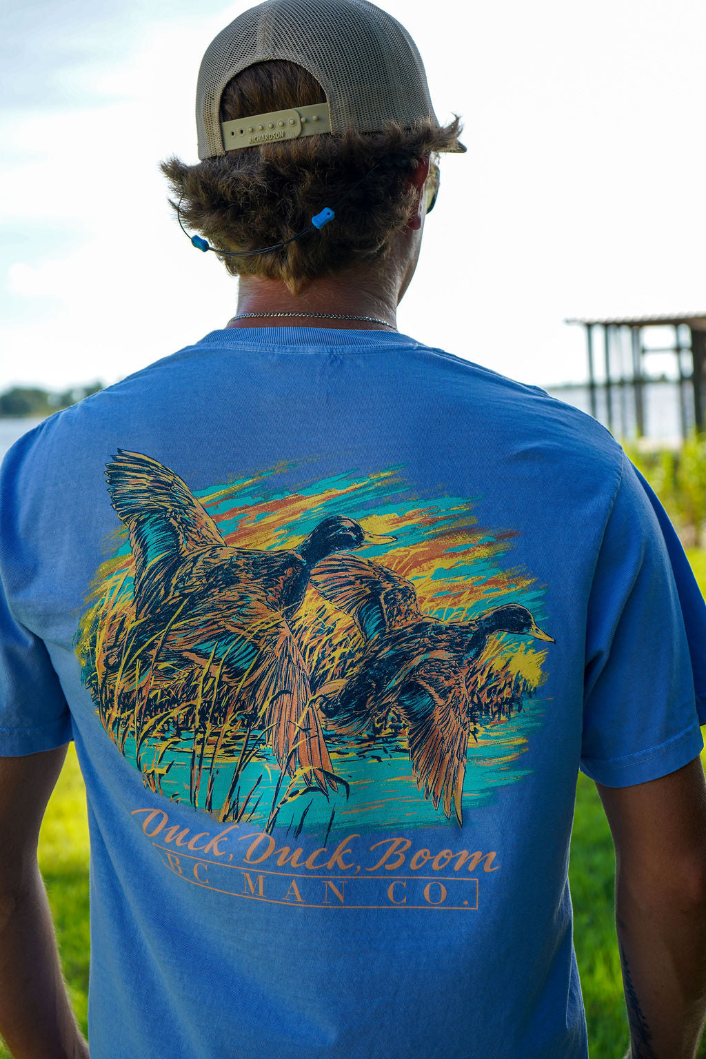 Man wearing the BC Man Co Duck, Duck, Boom garment-dyed blue duck hunting t-shirt with Blue Collar Man Company chest logo